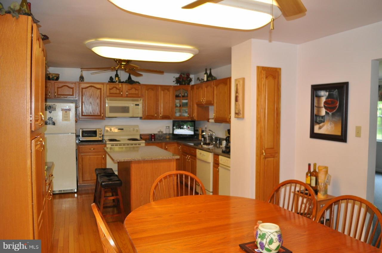 2531 Plum Point Road Huntingtown, MD 20639 - Photo 7 of 30 a kitchen with stainless steel appliances granite countertop a dining table chairs sink and stove top oven