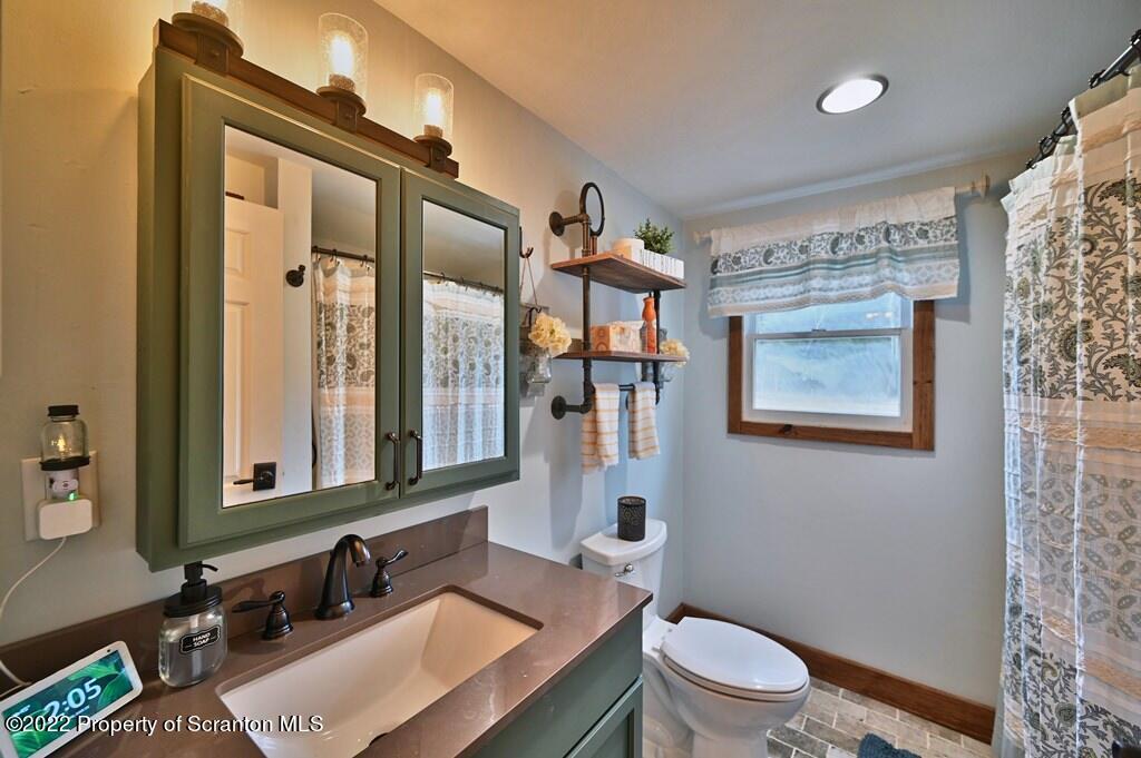 22 Suetta Lane Moscow, PA 18444 - Photo 16 of 53 a bathroom with a toilet a sink a mirror a window and vanity