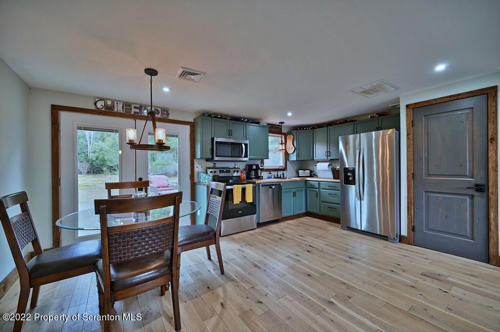 22 Suetta Lane Moscow, PA 18444 - Photo 7 of 53 a kitchen with stainless steel appliances wooden floor and dining table