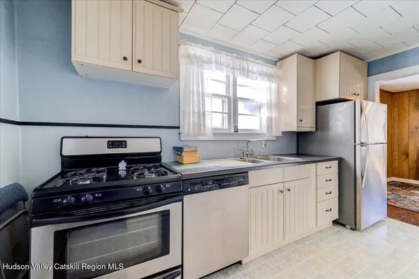 a kitchen with stainless steel appliances granite countertop a stove a refrigerator and a white cabinets
