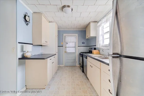 a kitchen with granite countertop a sink a counter space appliances and cabinets
