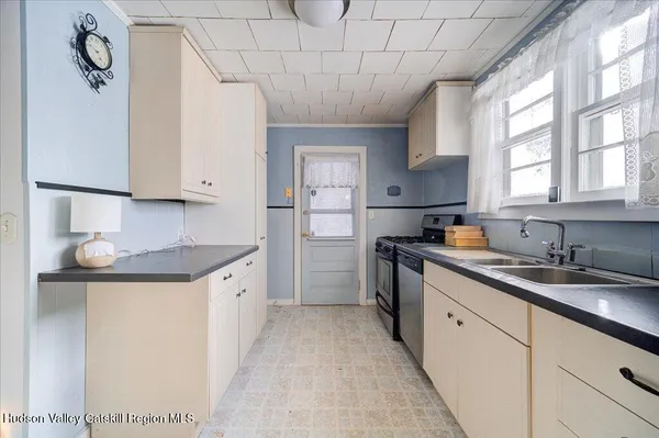 a kitchen with granite countertop a sink stainless steel appliances and cabinets