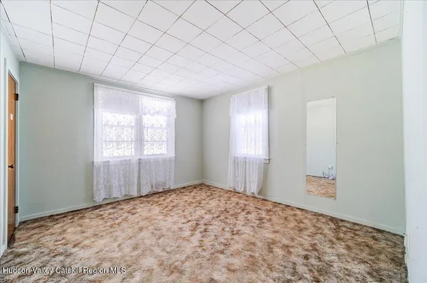 a view of a room with a window and wooden floor
