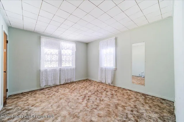 a view of a room with a window and wooden floor