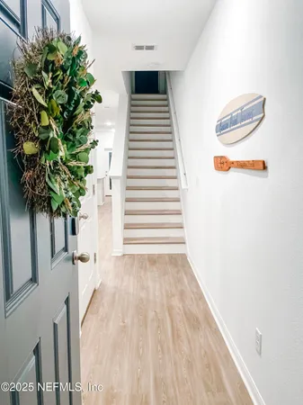 a view of a room with wooden floor and a potted plant