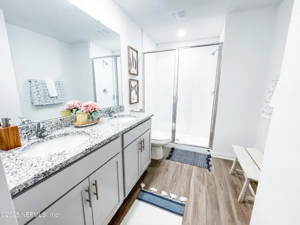 a bathroom with a granite countertop sink a mirror a vanity and shower