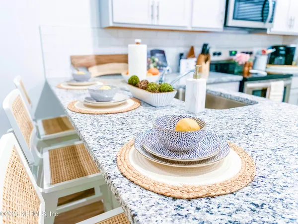 a kitchen with a stove a sink and a dining table