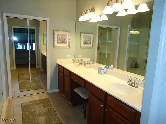 a bathroom with a double vanity sink mirror and shower
