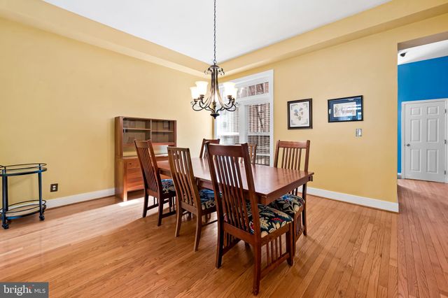 a dining room with furniture a chandelier and wooden floor
