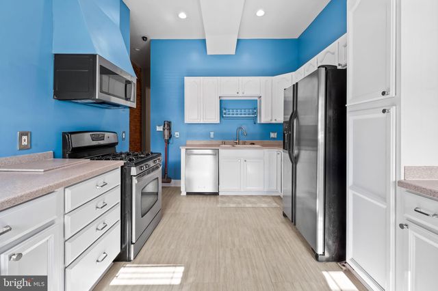 a kitchen with stainless steel appliances a refrigerator sink and cabinets
