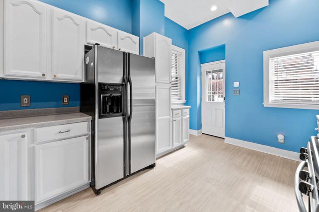 a kitchen with a refrigerator a sink and dishwasher with wooden floor