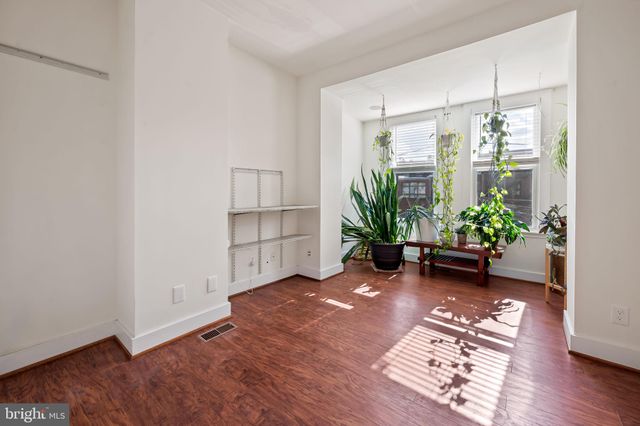 a view of an empty room with closet and wooden floor