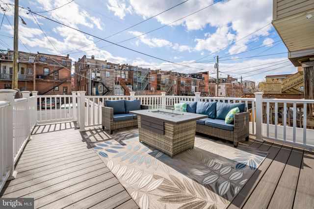 a view of a patio with couches chairs and wooden floor