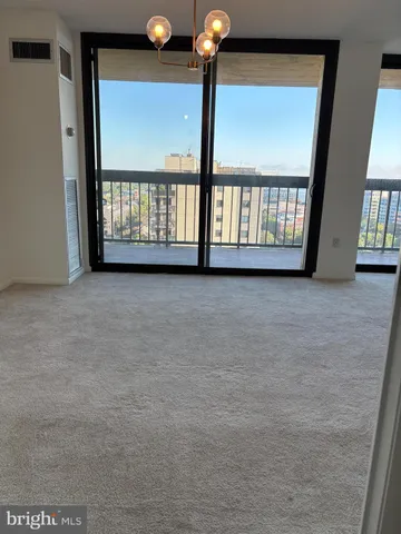 a view of an empty room with a chandelier fan