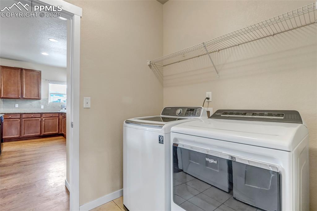 1822 Bulrush Way Colorado Springs, CO 80915 - Photo 16 of 37 a view of washer and dryer with kitchen in the background