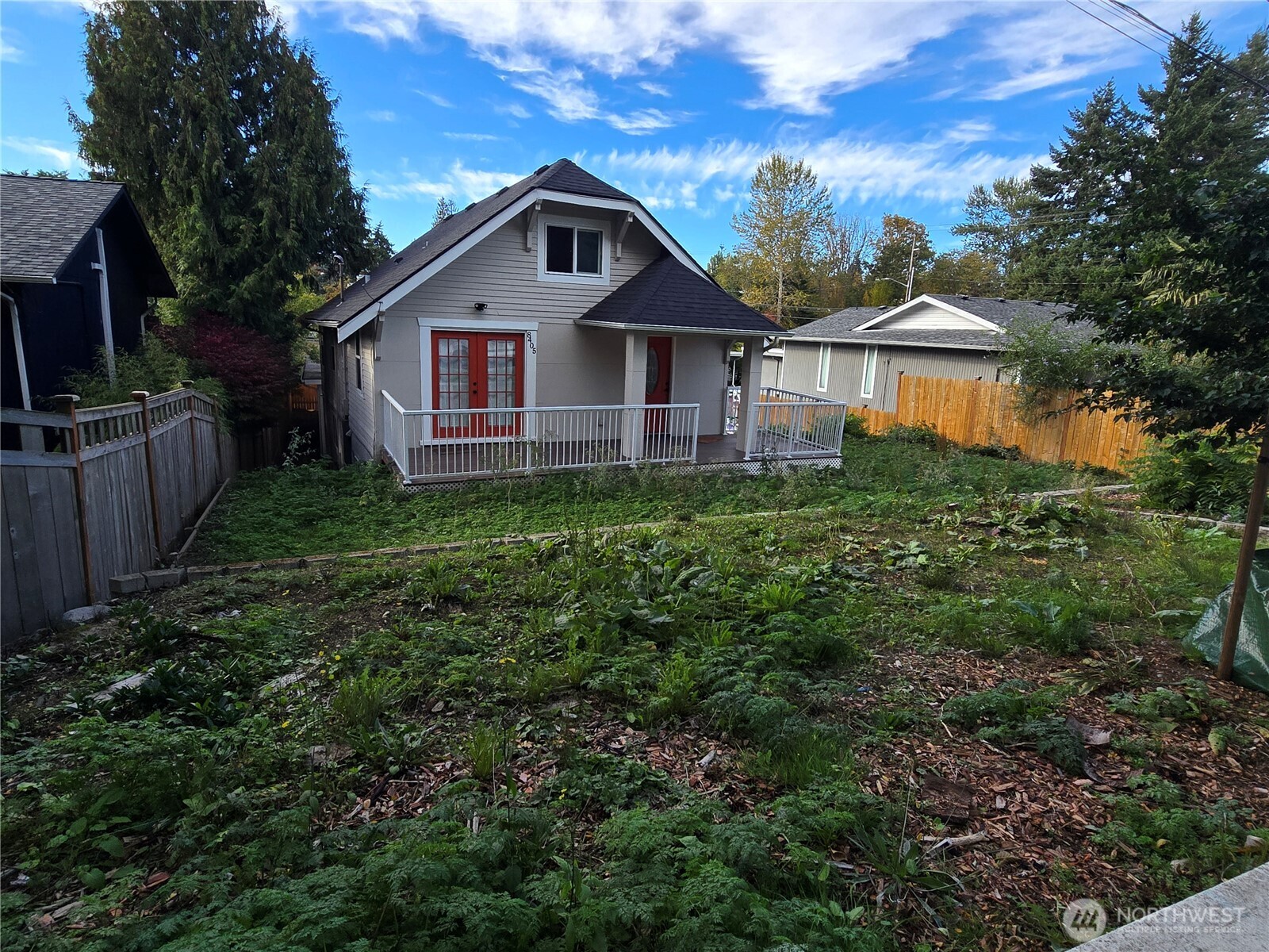 8405 24th Avenue Southwest Seattle, WA 98106 - Photo 1 of 14 a view of a yard in front of a house with plants and large trees