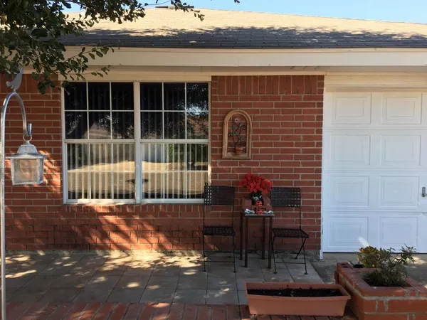 a view of a deck with a table and chair and floor to ceiling window