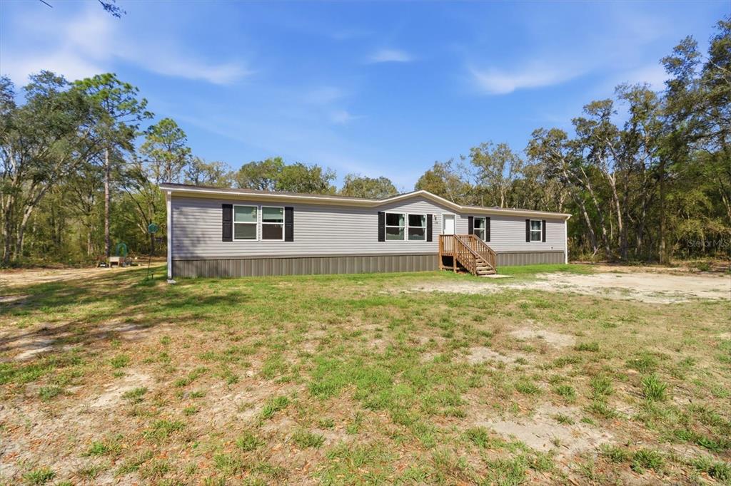 7290 Northeast 110th Avenue Bronson, FL 32621 - Photo 2 of 46 a front view of a house with a garden