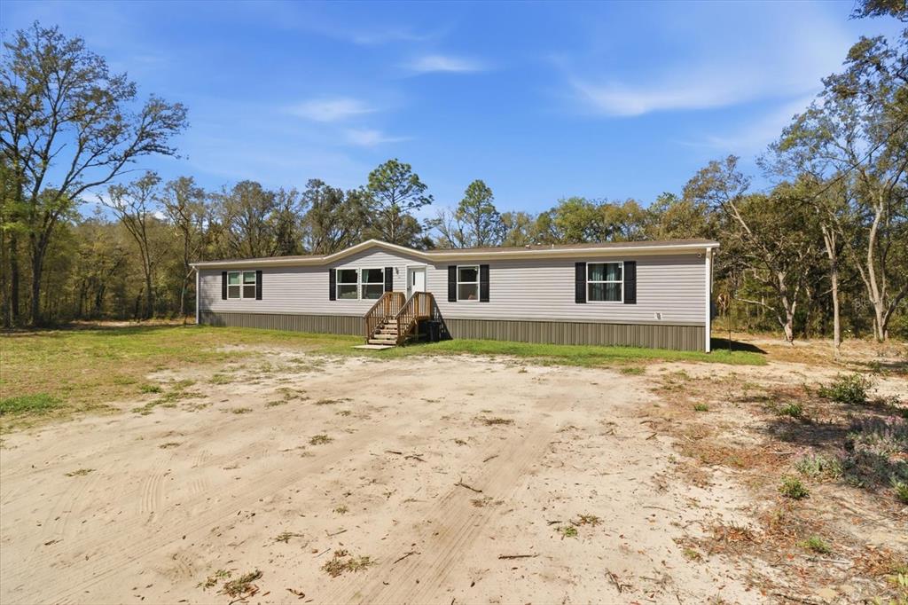 7290 Northeast 110th Avenue Bronson, FL 32621 - Photo 3 of 46 a front view of a house with a garden