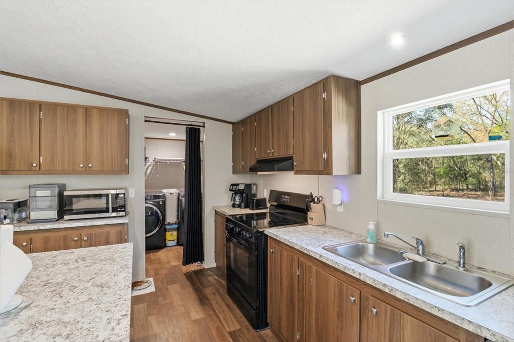 7290 Northeast 110th Avenue Bronson, FL 32621 - Photo 6 of 46 a kitchen with stainless steel appliances granite countertop a stove a sink refrigerator and a microwave