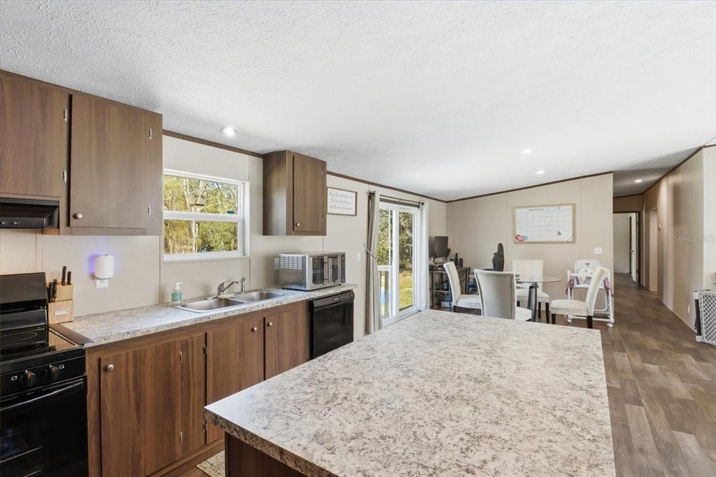 7290 Northeast 110th Avenue Bronson, FL 32621 - Photo 8 of 46 a kitchen with a stove a sink a refrigerator and a cabinets