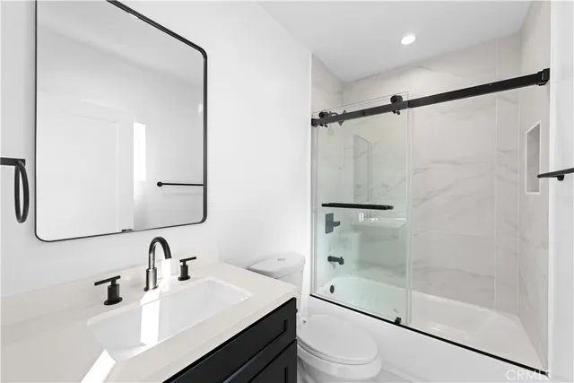 a bathroom with a sink mirror toilet and shower