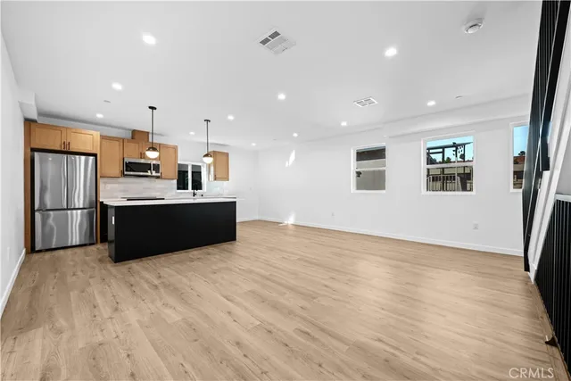 a view of kitchen with stainless steel appliances kitchen island wooden floor and window