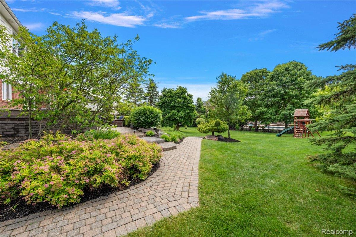 1422 Galena Rochester, MI 48306 - Photo 64 of 73 Expansive rear yard featuring a paver pathway, manicured lawn, and established landscaping