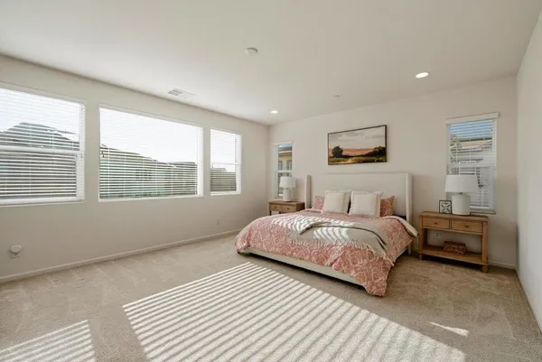 a bedroom with a bed a mirror and a window