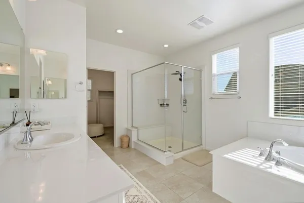 a spacious bathroom with a sink double vanity granite tub and shower