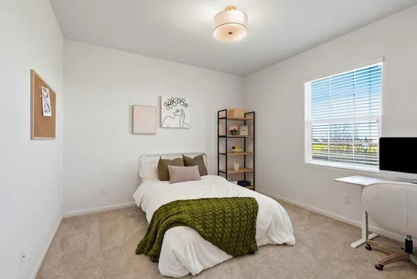 a bedroom with a bed and a painting on the wall
