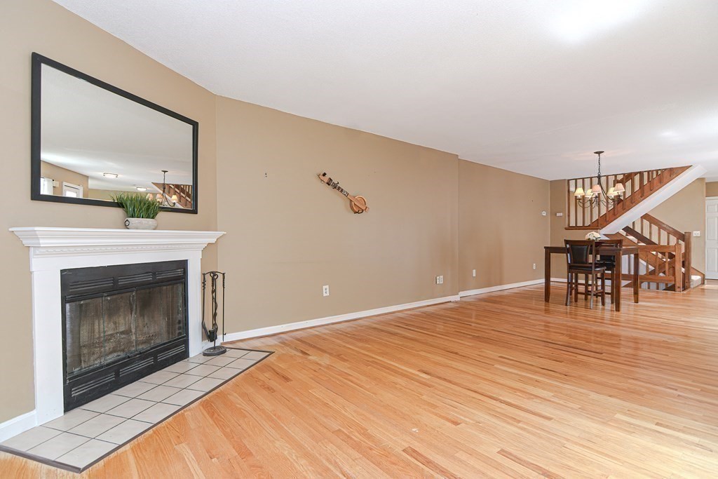 9 Crown's Way, Unit 9 Uxbridge, MA 01569 - Photo 13 of 40 a view of an empty room with wooden floor fireplace and a window