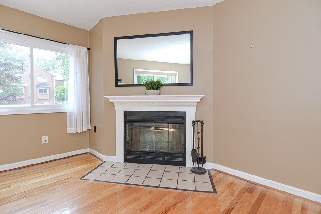9 Crown's Way, Unit 9 Uxbridge, MA 01569 - Photo 15 of 40 a living room with a fireplace and window
