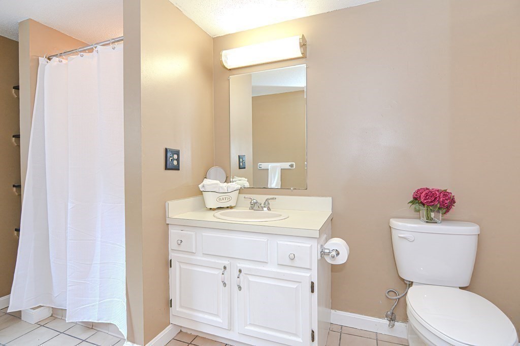 9 Crown's Way, Unit 9 Uxbridge, MA 01569 - Photo 20 of 40 a bathroom with a sink mirror vanity and toilet