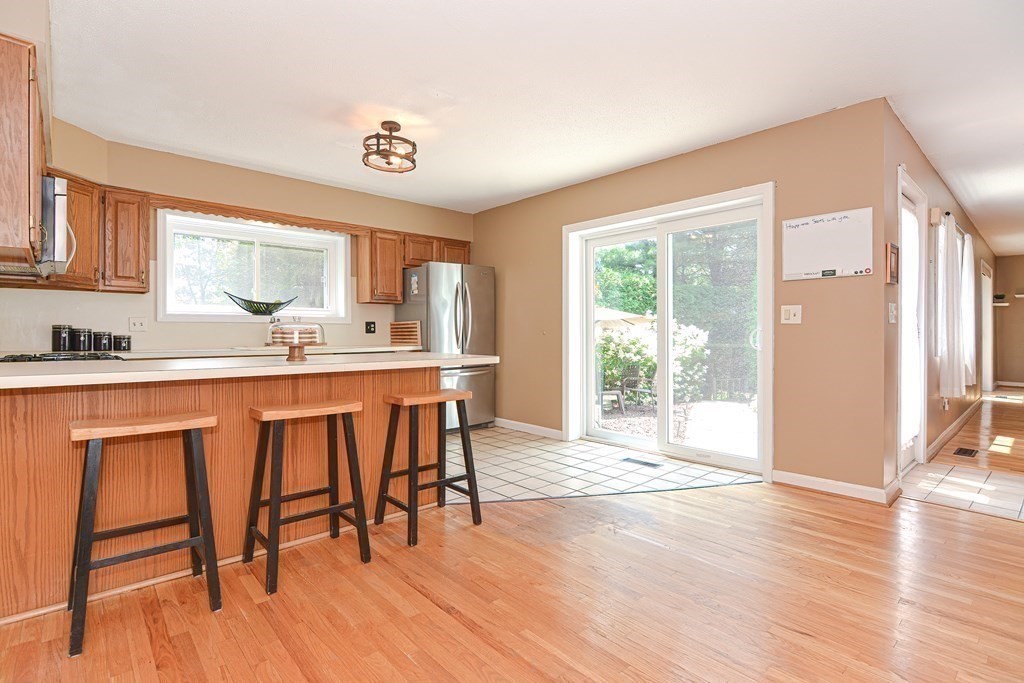9 Crown's Way, Unit 9 Uxbridge, MA 01569 - Photo 2 of 40 a kitchen with stainless steel appliances granite countertop a stove a sink and a refrigerator with wooden floor