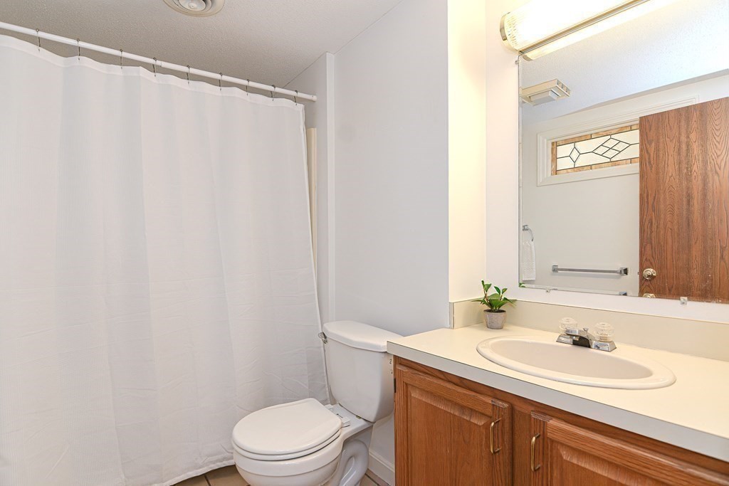 9 Crown's Way, Unit 9 Uxbridge, MA 01569 - Photo 23 of 40 a bathroom with a sink a toilet and a mirror