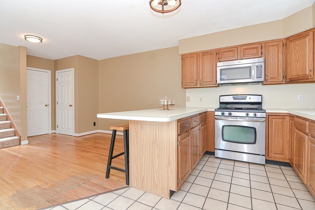 9 Crown's Way, Unit 9 Uxbridge, MA 01569 - Photo 3 of 40 a kitchen with a stove sink and cabinets