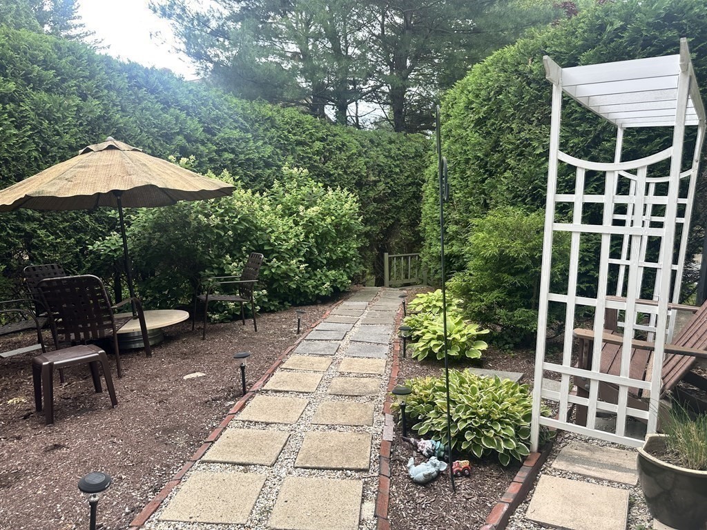 9 Crown's Way, Unit 9 Uxbridge, MA 01569 - Photo 35 of 40 a view of a patio with table and chairs potted plants
