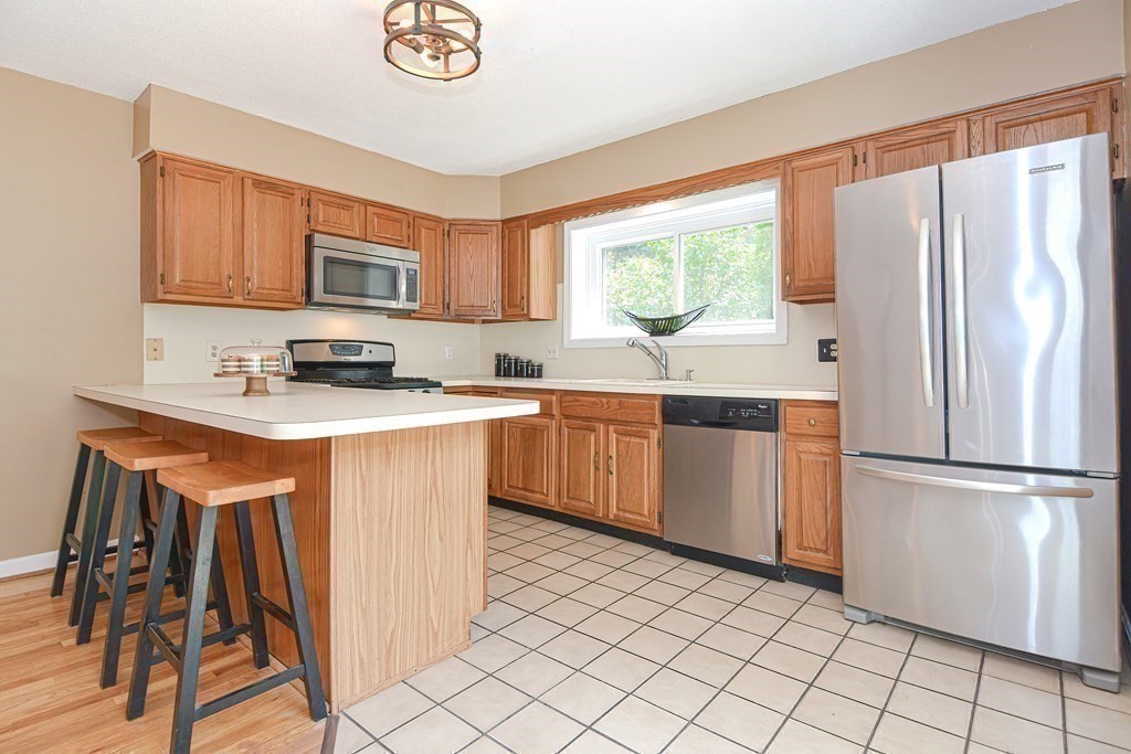 9 Crown's Way, Unit 9 Uxbridge, MA 01569 - Photo 4 of 40 a kitchen with stainless steel appliances granite countertop a refrigerator sink and cabinets