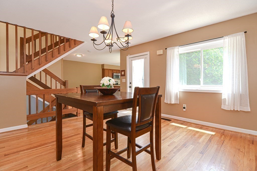 9 Crown's Way, Unit 9 Uxbridge, MA 01569 - Photo 10 of 40 a view of a dining room with furniture a chandelier and wooden floor