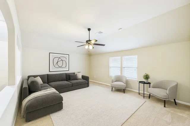 a living room with furniture and a ceiling fan