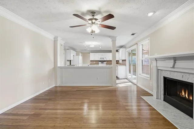 a view of a kitchen with wooden floor and a fireplace