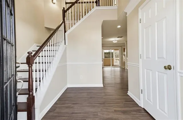 a view of a hallway with wooden floor and staircase