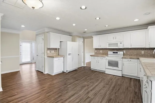a kitchen with white cabinets stainless steel appliances and a center island