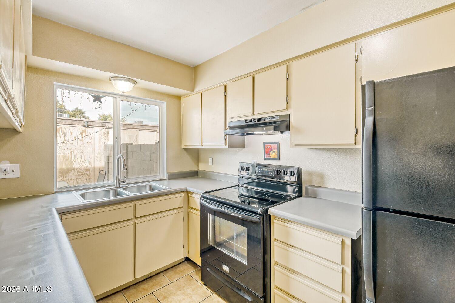 4625 West Thomas Road, Unit 39 Phoenix, AZ 85031 - Photo 11 of 27 a kitchen with stainless steel appliances a refrigerator sink and stove