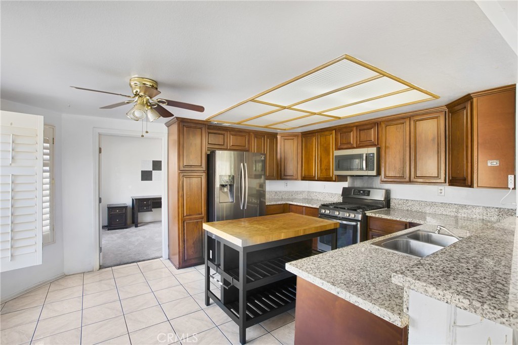 24321 Barley Road Moreno Valley, CA 92557 - Photo 15 of 66 a kitchen with stainless steel appliances granite countertop a sink and a refrigerator