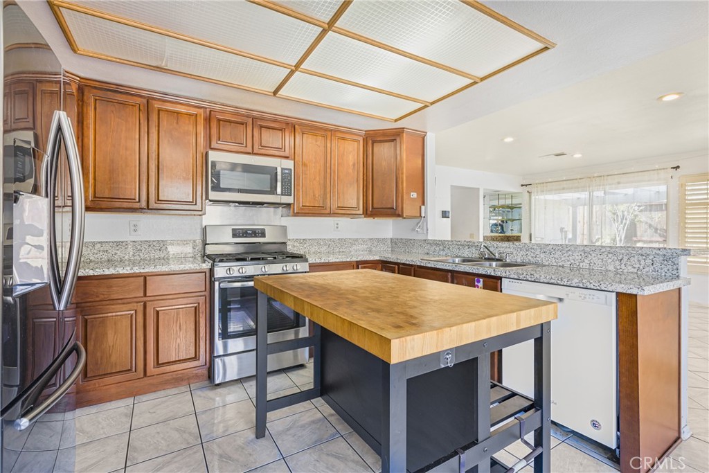 24321 Barley Road Moreno Valley, CA 92557 - Photo 17 of 66 a kitchen with stainless steel appliances granite countertop a stove a sink and a microwave