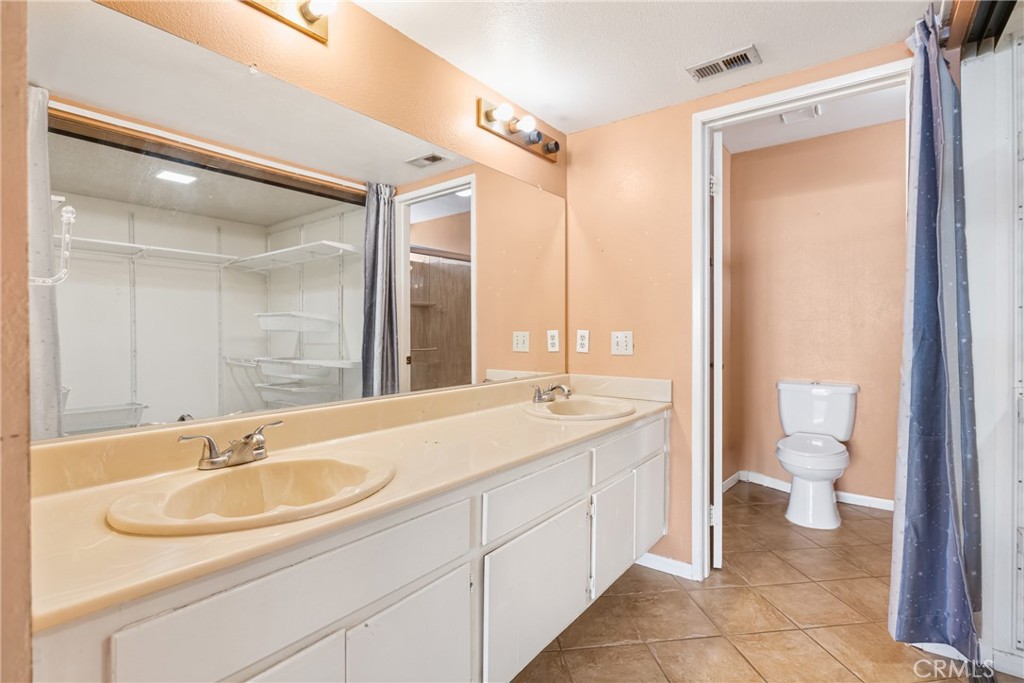 24321 Barley Road Moreno Valley, CA 92557 - Photo 26 of 66 a bathroom with a sink double vanity and a toilet