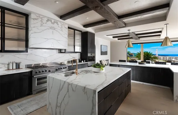 a living room with furniture a chandelier and a dining table with kitchen view