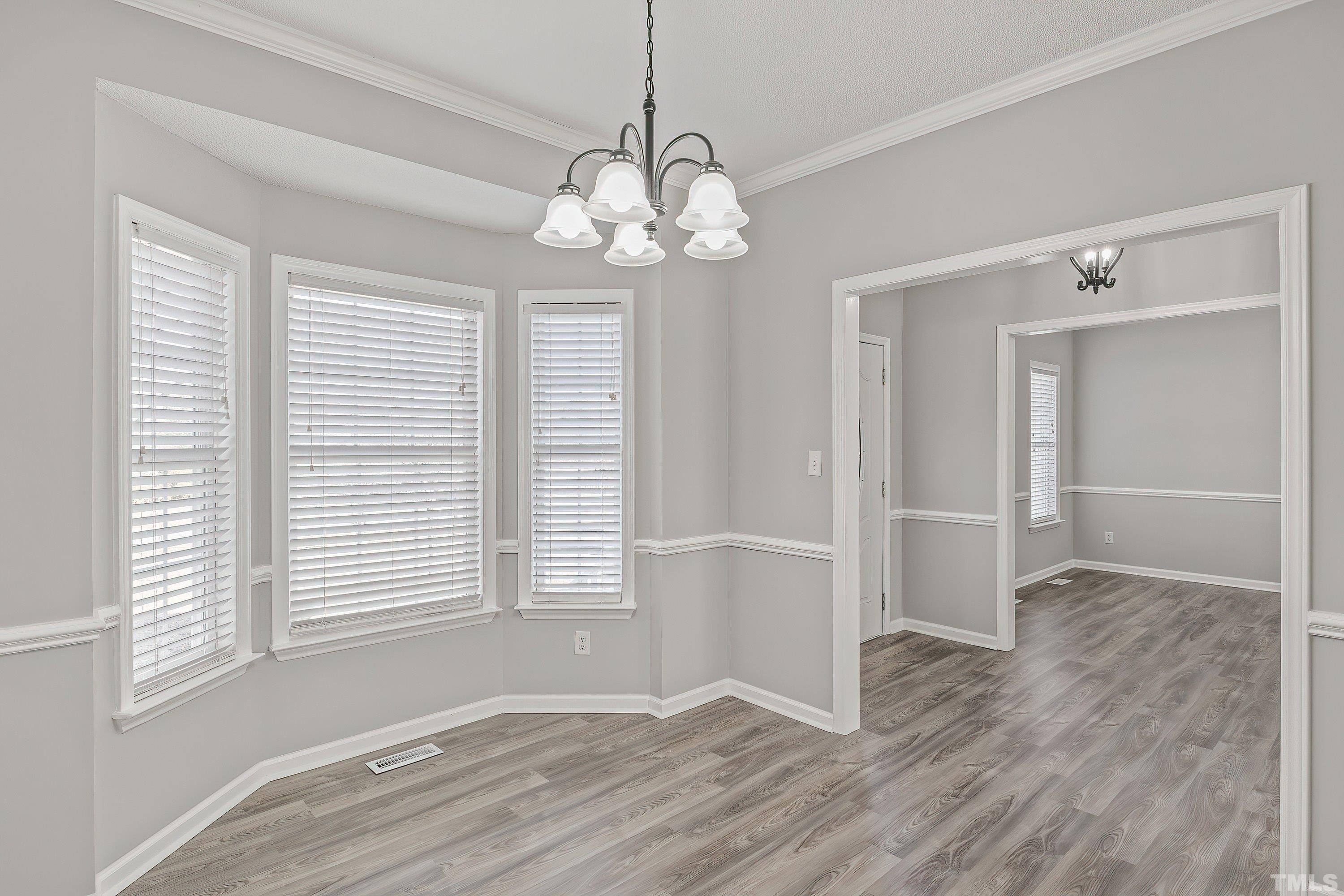 1008 Linden Crest Road Raleigh, NC 27603 - Photo 6 of 37 an empty room with wooden floor and windows